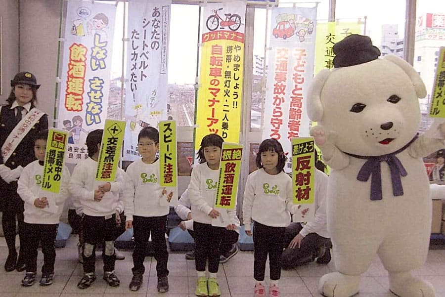 ▲JR王寺駅で幼稚園児とマスコットキャラクター「雪丸くん」が交通安全啓発