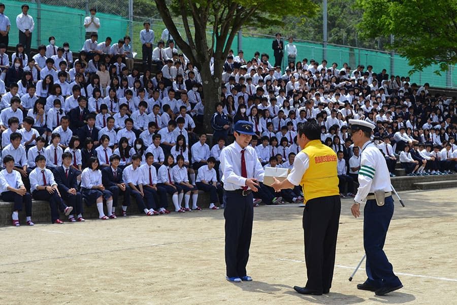 ▲県立登美ヶ丘高校の自転車通学者に「サイクルリフレクター」を贈呈