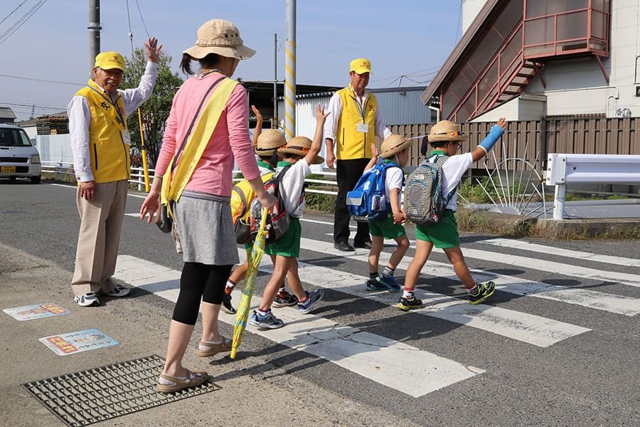 ▲園児の安全を願い交差点で誘導活動（田原本地区）