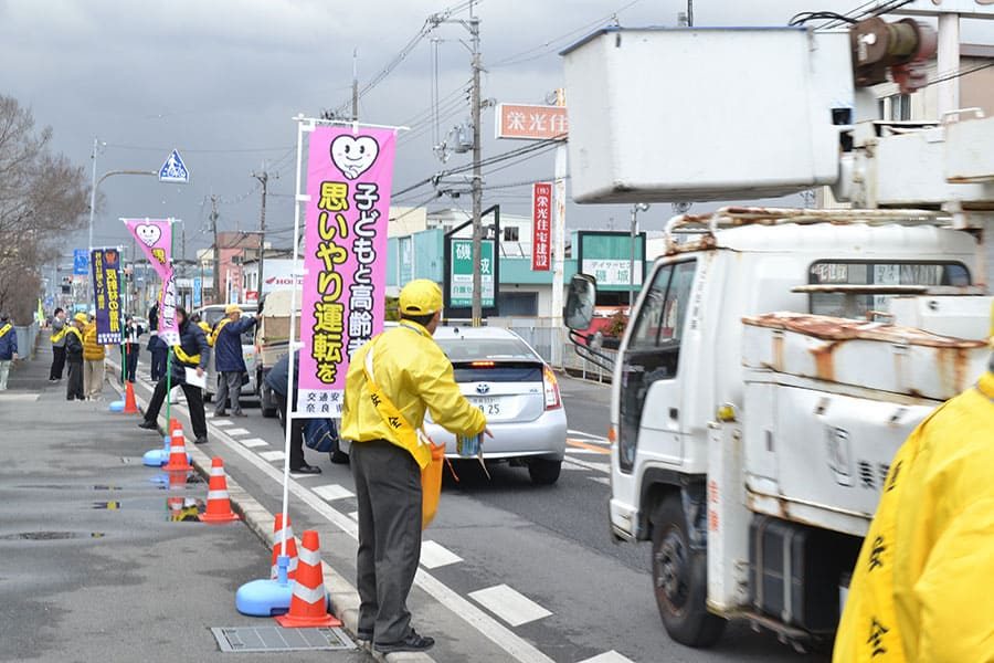 ▲国道24号線で横断歩行者の保護を呼びかけるチラシや安全グッズを配布